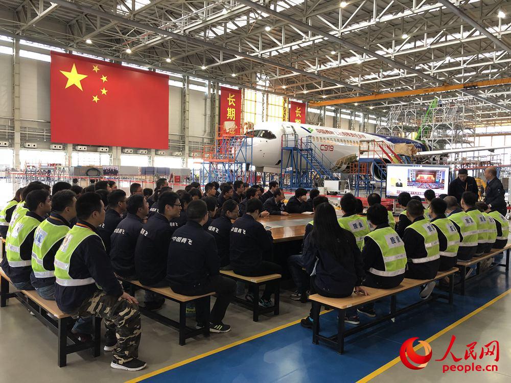 10月18日上午，中国商飞公司上海飞机制造有限公司浦东基地工作人员正在观看十九大开幕会。人民网王文娟 摄