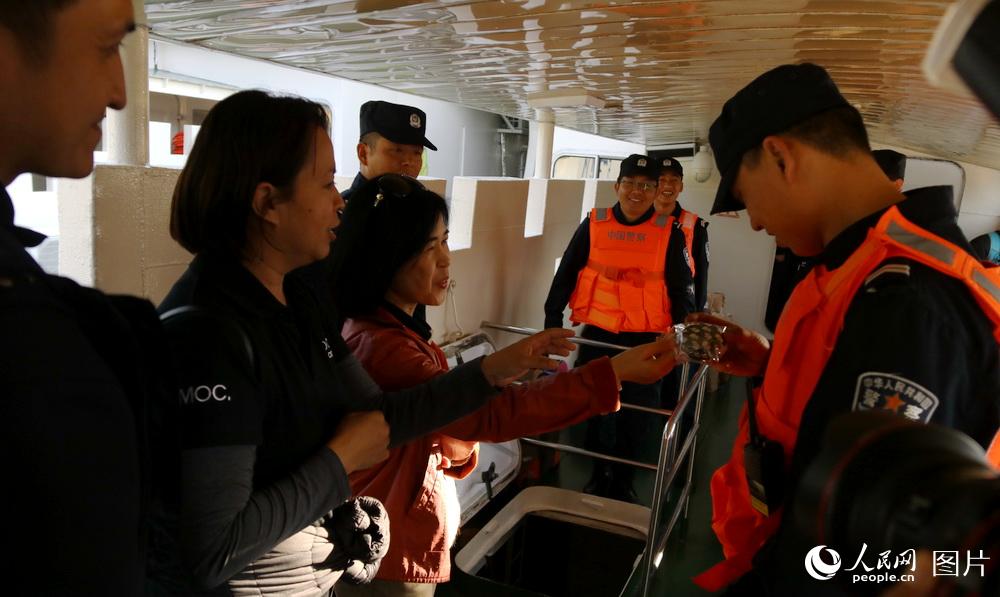 国巡逻艇时向一名中国边防警察赠送小纪念品