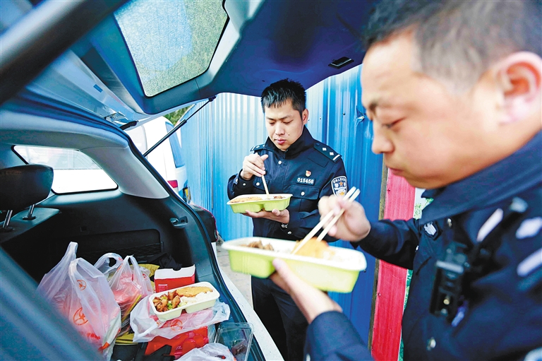 警察在警車旁吃工作餐
