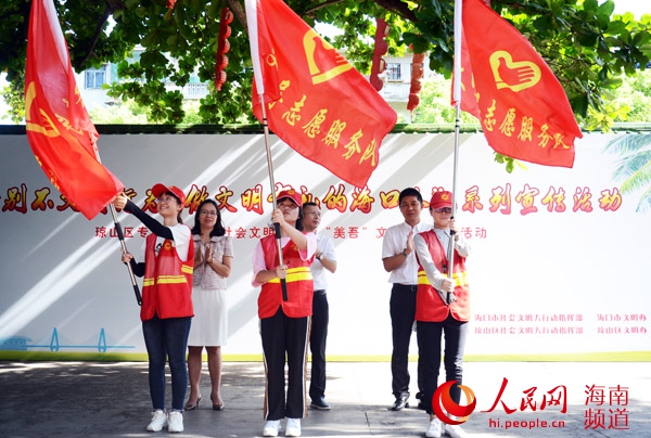 参与活动的领导向文明劝导志愿服务队授旗。何青松 摄