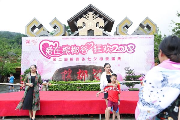 七夕相亲庆典主会场搭建完毕,游客在会场主题背景前合影留念