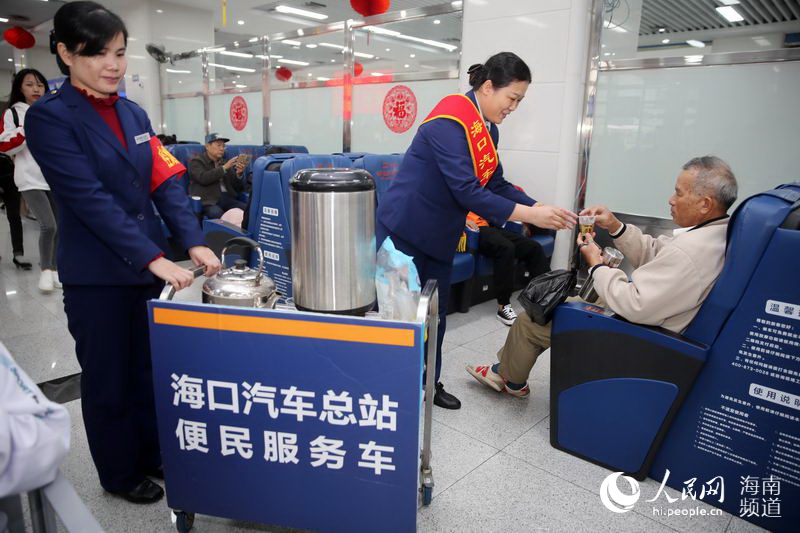 “春運”首日，海口汽車客運總站工作人員為候車旅客送熱茶。
