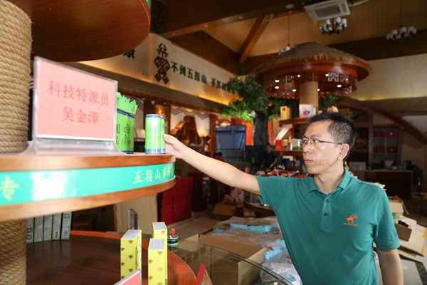 五指山市科技特派員吳金漳在展示當地特色電商產品。(李天平攝)