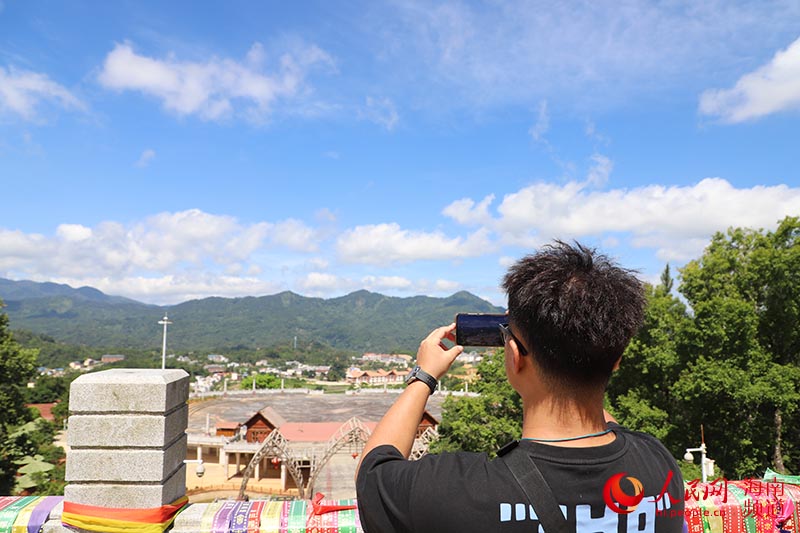拍客站在高處拍攝遠山的風景。牛良玉攝
