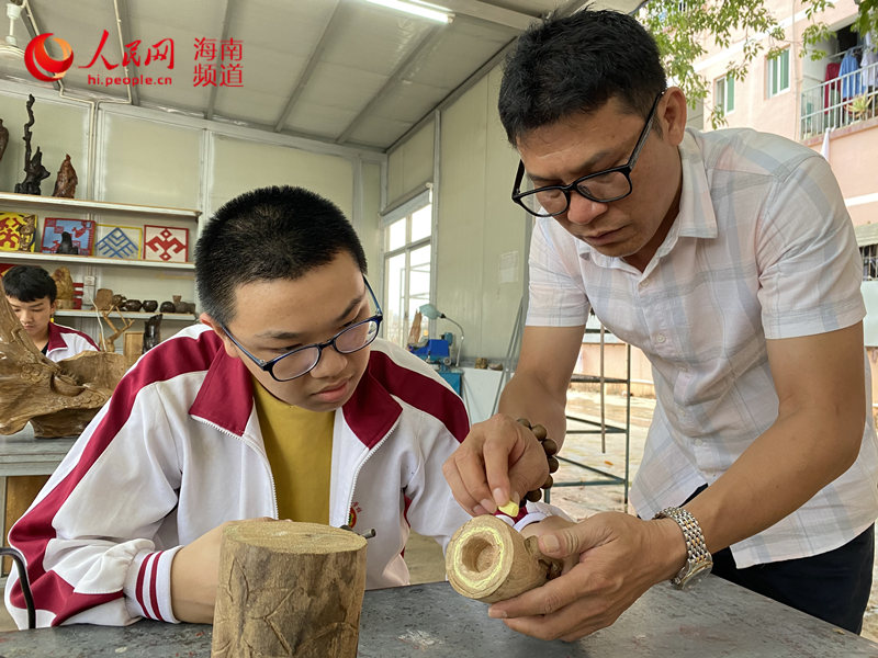 蔣友鋒教學生雕刻木料。人民網 樊歡迪攝