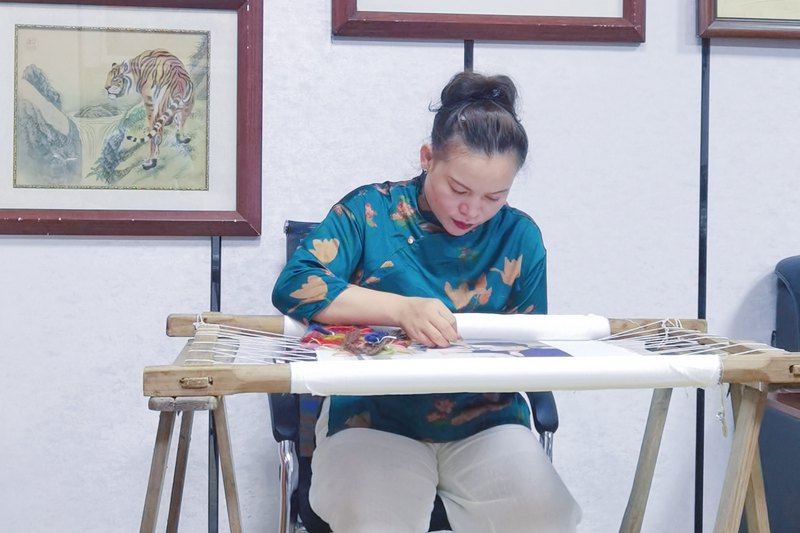 蔣藝鴻在工作室完成苗繡作品。受訪人供圖