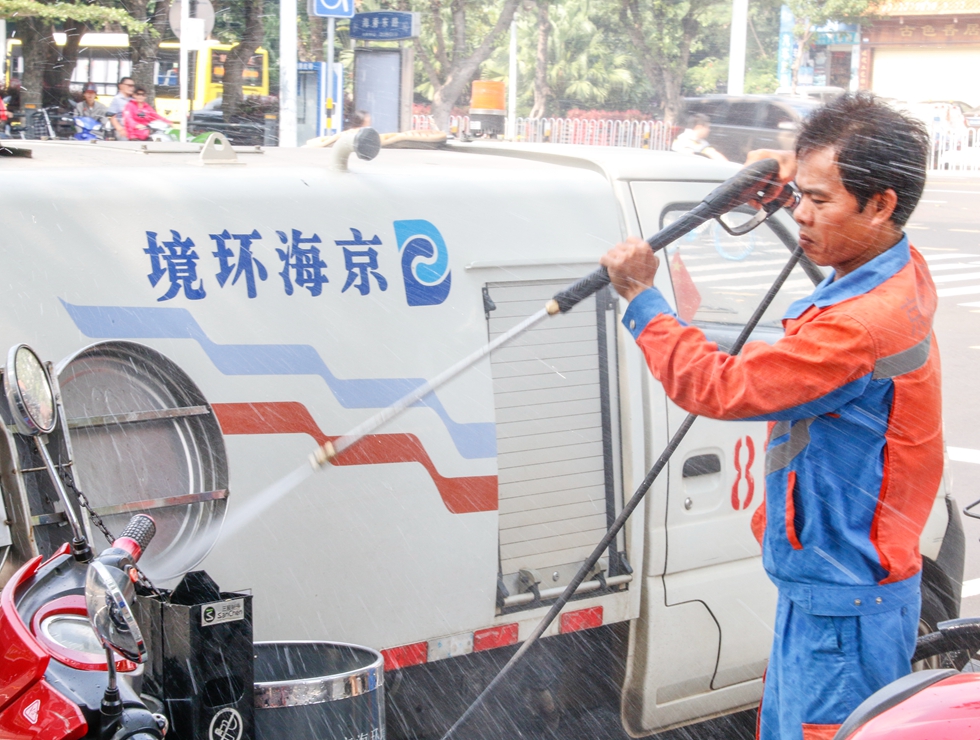 海口京蘭公司環衛公司工人韋迫民在沖洗果皮箱