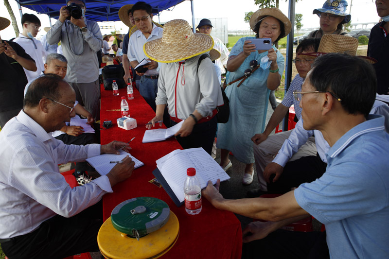 测产专家组组长、中国科学院院士谢华安（左）和其他专家在计算早稻平均亩产量。尚野摄