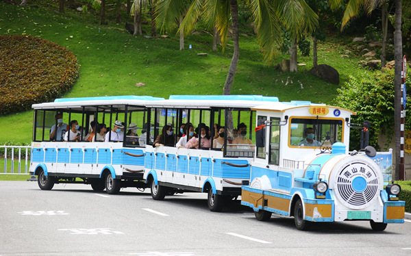5月25日，游客乘坐“小火车”在三亚南山文化旅游区游览