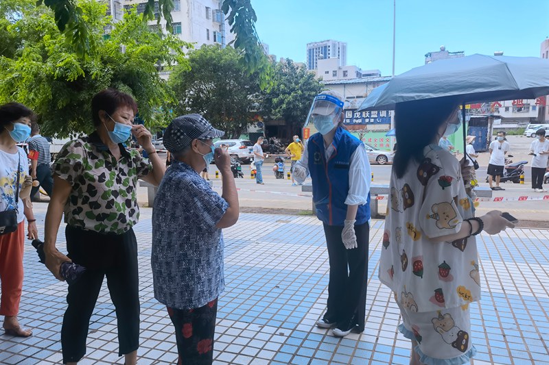 志愿者杨奔（右二）在检测点做指引工作。受访人供图