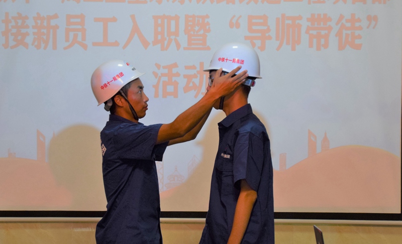 师傅为徒弟戴上安全帽。何传瑞摄