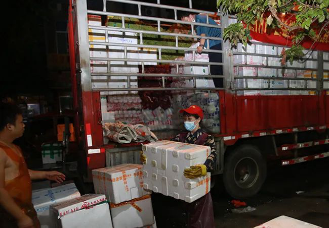 圖為工作人員在蔬菜銷售網點卸貨。