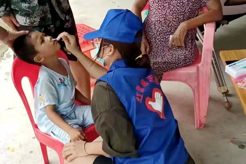 东方市大田镇青年志愿者为幼童做抗原检测。
