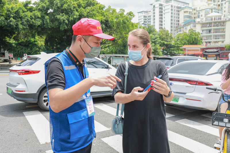 志愿者为外国游客解答问题。吉阳区委宣传部供图