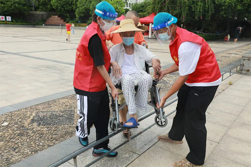 志愿者帮助行动不便老人完成核酸采样（陈晨 摄）