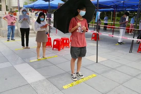 群众保持一米安全距离有序排队。杨萍摄