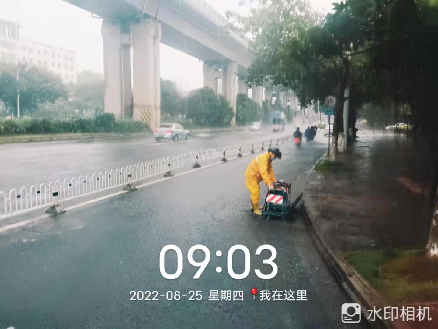 排水工人在路面上做好雨天排水工作。