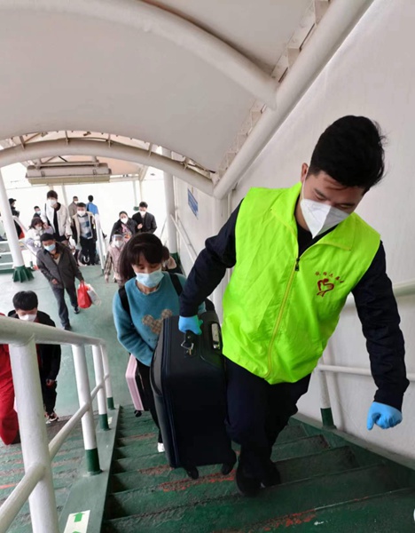 “志愿绿”协助旅客登船。陈江奇摄