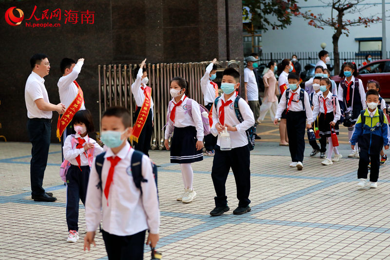 高年级同学行少先队员礼欢迎同学返校。 人民网 孟凡盛摄