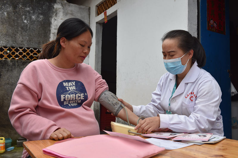 医生薛女强在给留守孕妇张玉秋测量血压。林小丹摄