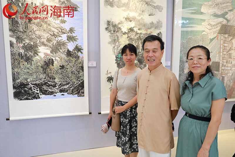 画家陈兆堤（左二）与他的作品《黎家春风》。人民网 孟凡盛摄