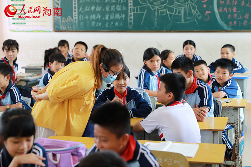 在临高县新盈中心学校，老师与学生们互动。 人民网 孟凡盛摄