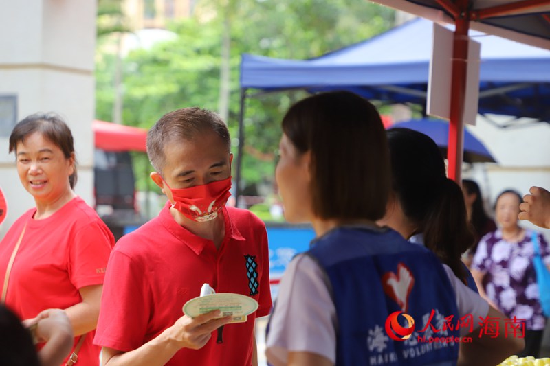 志愿者为家长提供降暑物资。人民网记者 樊欢迪摄