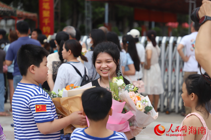 小朋友们手捧鲜花迎接姐姐。人民网 牛良玉摄