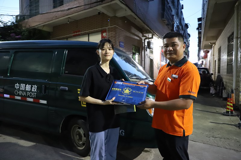 杜小意（左）和中国邮政工作人员展示高考录取通知书。黄文燕摄