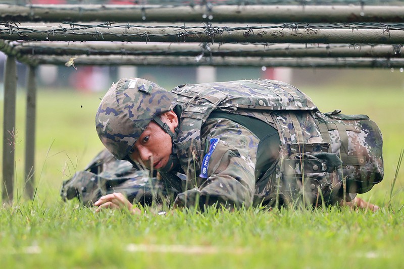 参赛官兵全副武装通过低桩网。武警海南总队供图