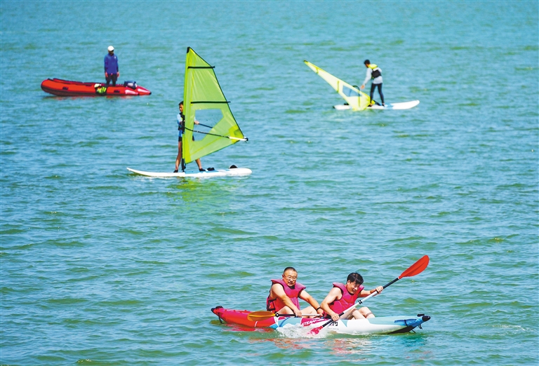 游客在海口西海岸体验桨板等水上运动。