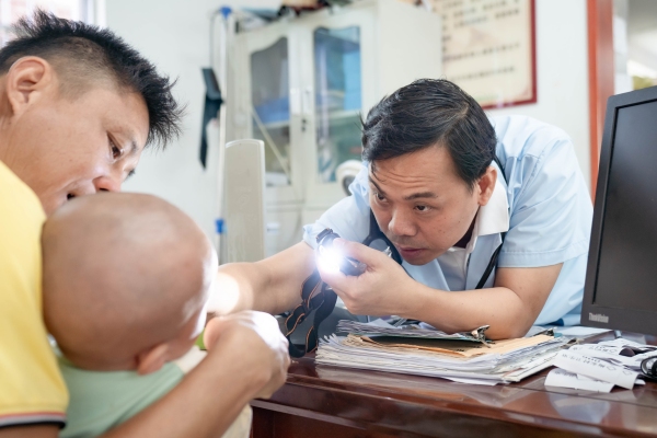 三亚市崖州区梅东村卫生室全科副主任医师蔡优为村民看病。