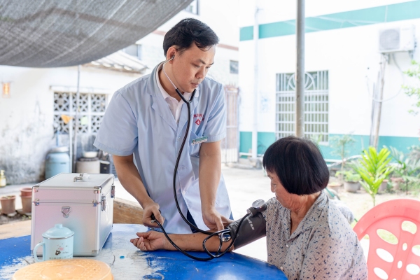 三亚市崖州区梅东村卫生室全科副主任医师蔡优为村民看病。