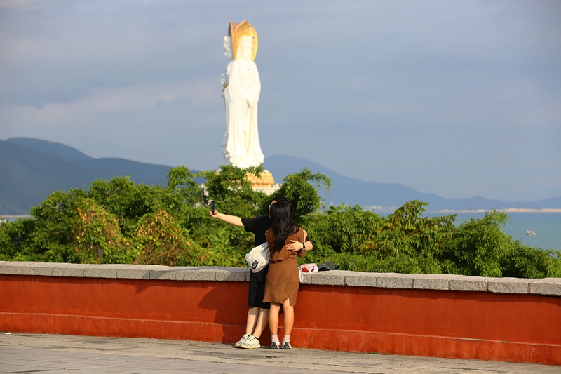 初冬时节，一对情侣在三亚南山文化旅游区海边游览