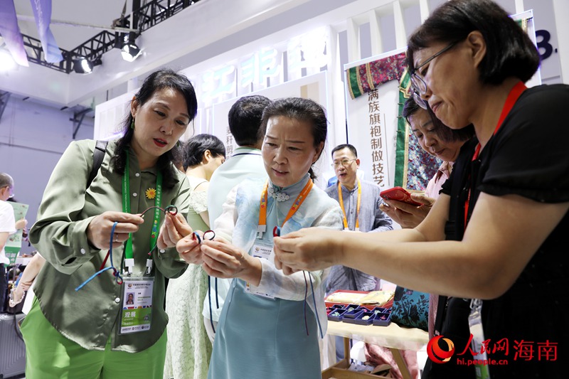 非遺技藝傳承人現場教學制作滿族旗袍盤扣。人民網記者 符武平攝