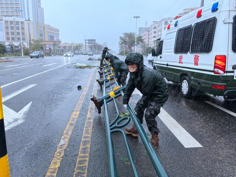 武警海口支队官兵正在恢复被大风吹倒的公路隔离带。房立摄