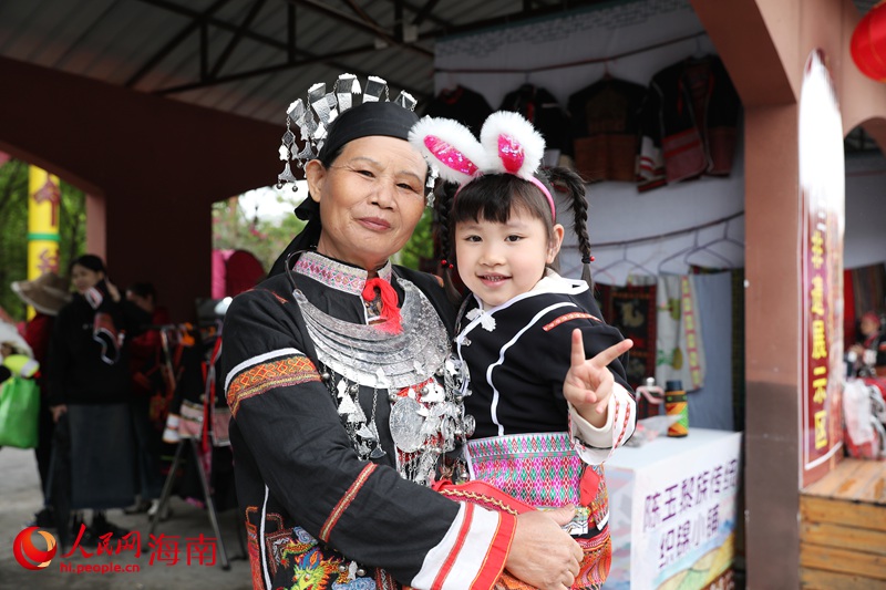 市民游客穿着黎锦服装拍照合影。人民网记者 符武平摄