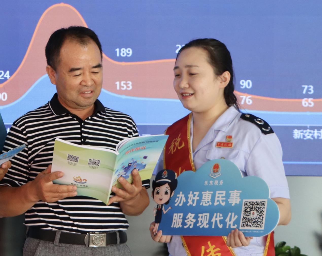 吳佳蔚在對納稅人進行稅費政策輔導。潘瑩攝