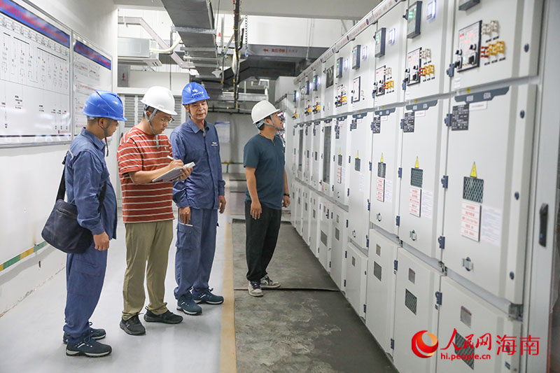 企業秘書與供電所、企業相關負責人走進變電房了解情況。人民網記者 牛良玉攝