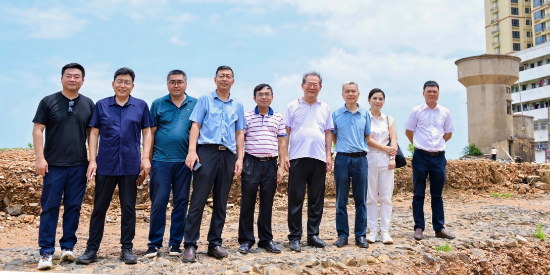 考察组在老城镇通潮驿原址合影留念，脚下石层平面是考古专家勘探发掘出的古代石铺驿道，右侧水塔位置是经多方面专家考证的通潮阁遗址。