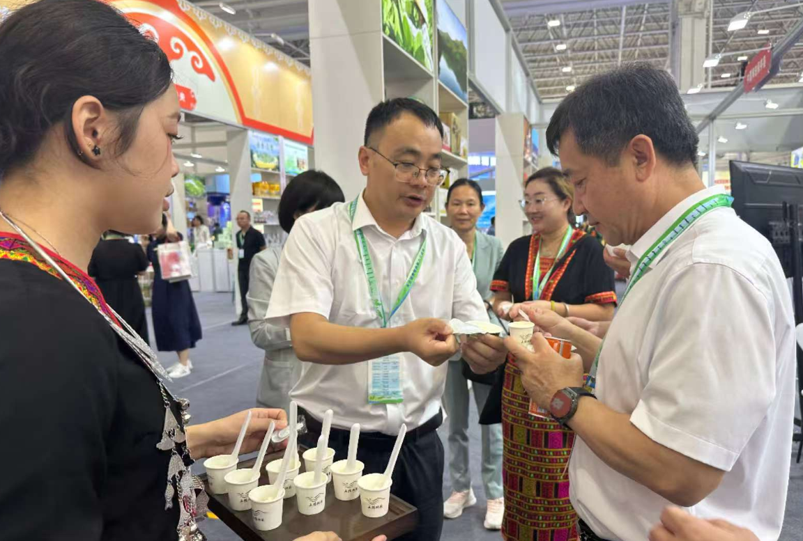 中國海油鄉村振興挂職干部、五指山市副市長縣長李曉濤（中）參加消費幫扶活動的照片，推廣五指山紅茶。受訪者供圖