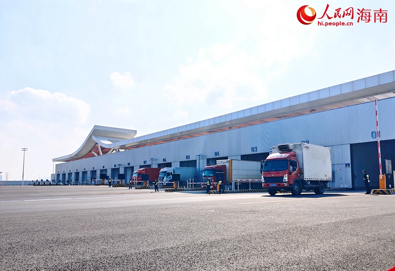 在海口新海港和南港"二线口岸"(货运)集中查验场，货运车辆通过闸口驶向放行通道。人民网记者牛良玉摄