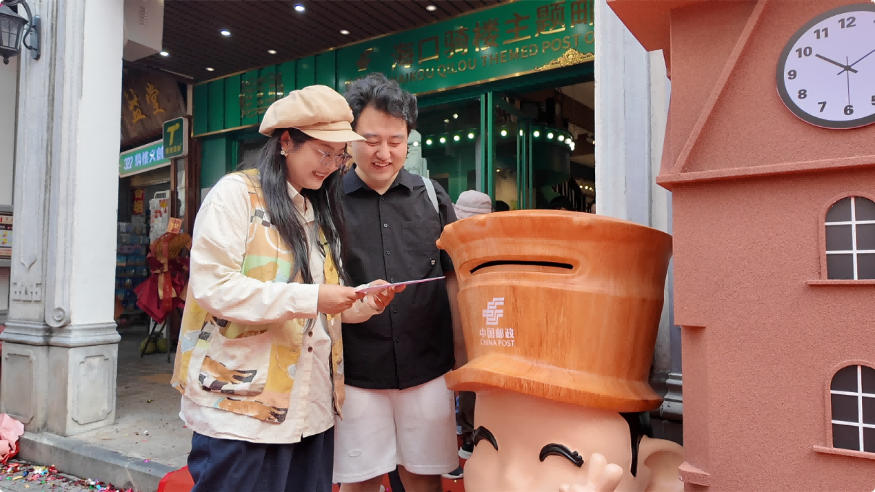 外地游客在海口騎樓郵局體驗郵政服務。黃文燕攝