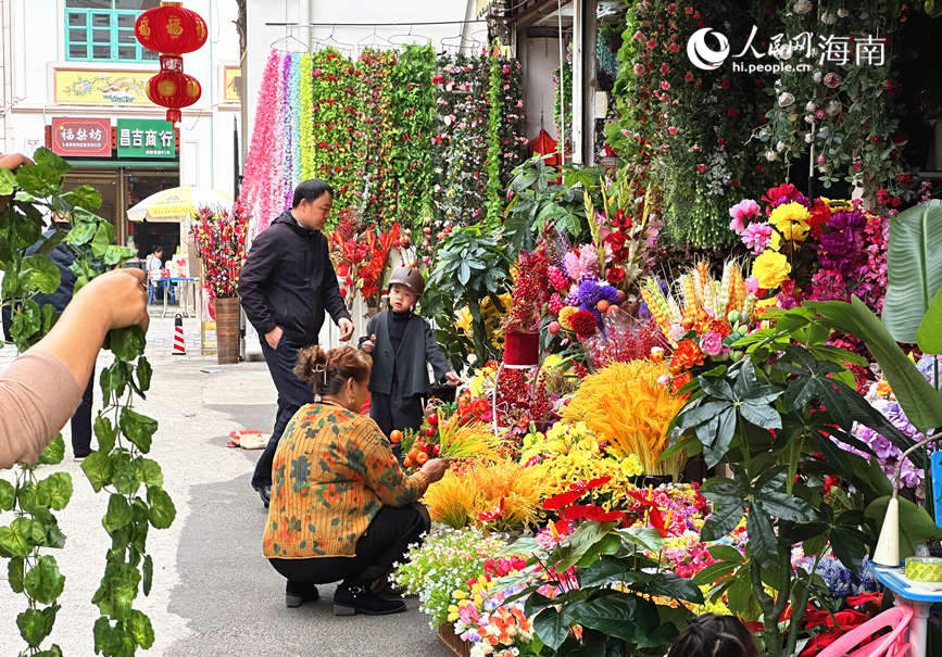 在一片姹紫嫣红中，市民精心挑选寓意吉祥的年宵花，为家中增添生机与喜庆。人民网 刘杨摄