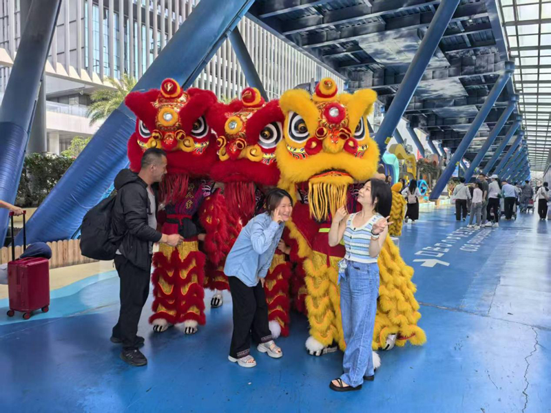 在三亞鳳凰國際機場，游客與舞獅互動。海南省旅文廳供圖