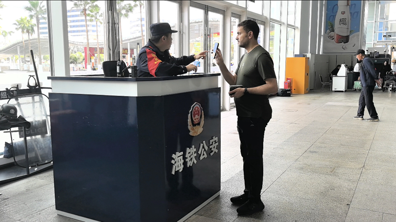 執勤民警為外籍乘客核對相關信息。海口東站派出所供圖