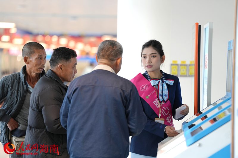 工作人员正在帮助乘客购票。人民网记者 符武平摄