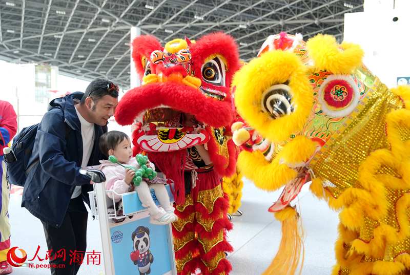 海口新海港年味浓，小朋友和舞狮互动。人民网记者 符武平摄