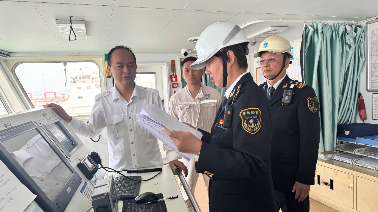 海事部門工作人員檢查船舶航行資料。海口海事局供圖