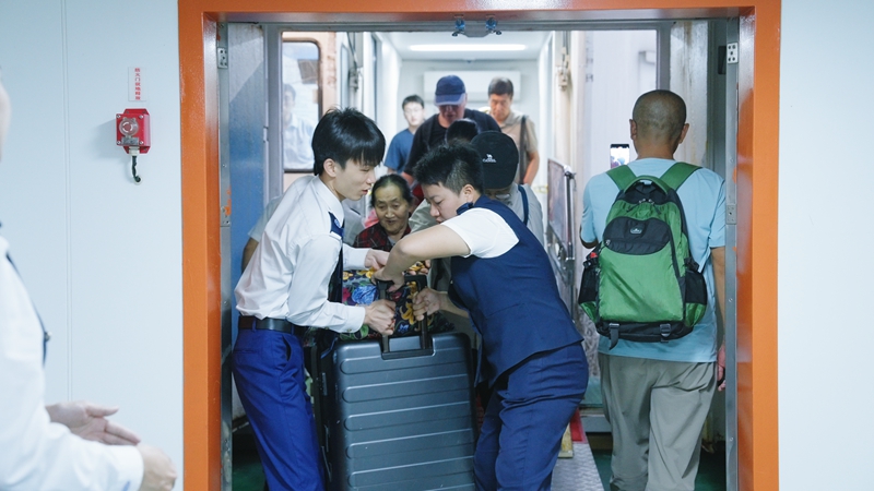 乘務員幫助旅客抬大件行李。海峽股份供圖